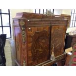 A reproduction Italian style walnut two door cocktail cabinet with brass edged decoration.