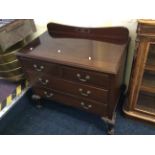 A two short drawer, two long drawer mahogany chest of drawers with ball and claw feet.