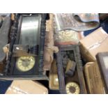 Four wall clocks, two framed in wood and one in a glass cabinet.