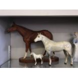 Wood mounted ceramic model horse along with two glazed ceramic model horses.