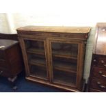A walnut Victorian bookcase with three drawers.