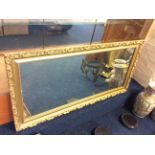 A wall mirror with a gilded Classical wooden frame.