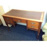 A five drawer Edwardian mahogany desk with turned legs.