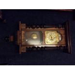 An oak cased Vienna wall clock with column sides.