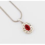 An 18ct white gold ruby and diamond pendant, with a central oval ruby, measuring approx. 6x4mm,