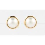 A pair of mabe pearl stud earrings, framed in indistinctly stamped yellow metal.