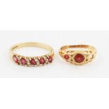 An 18ct yellow gold three stone ring, centrally set with a round cut garnet, flanked to one side