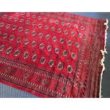 A red ground rug with repeat medallion design with medallion design border, length 395cm, width