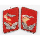 A pair of German Luftwaffe flak collar badges, each having silver coloured embroidery on red