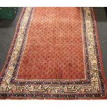 A red ground sarouk design Persian rug, approx. length 318cm.