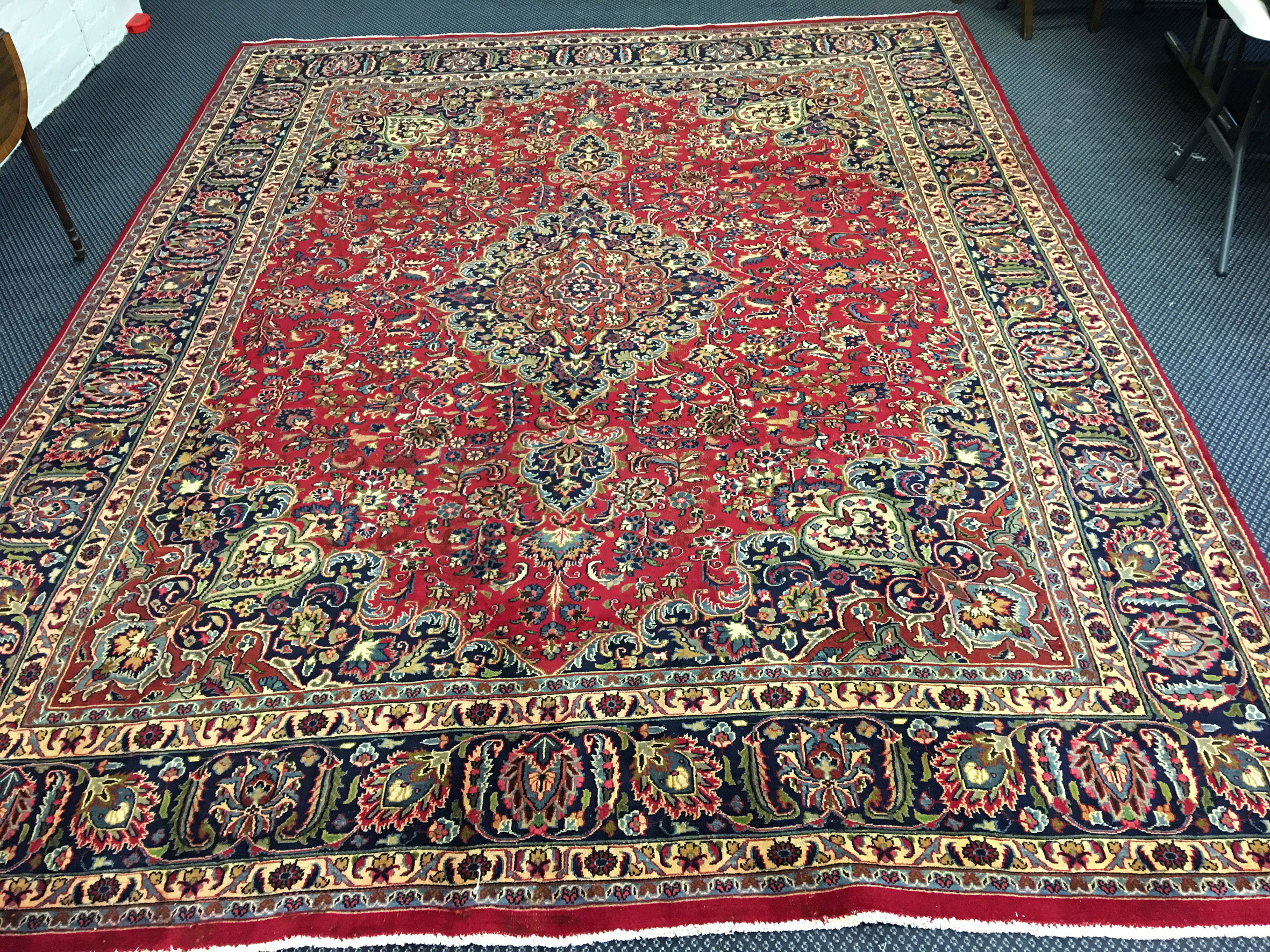 A large Persian Mashad rug with busy overall design all on red ground, length 385cm, width 295cm.