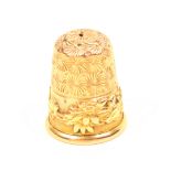 A 9ct. gold thimble by Charles Horner, the ribbed frieze with overlaid floral band.