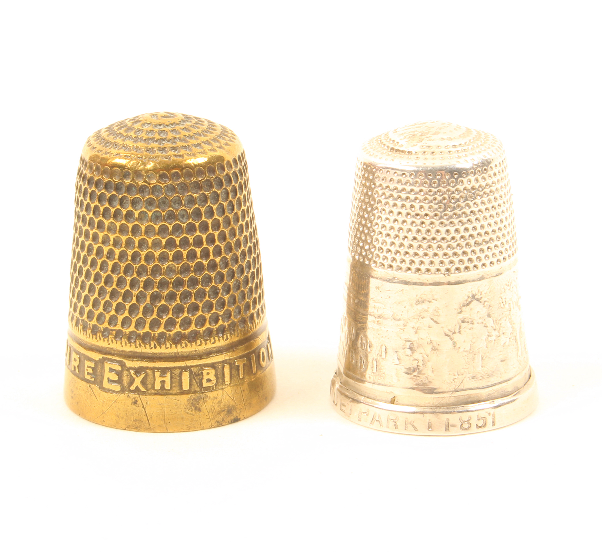 Two exhibition souvenir thimbles comprising a silver – Great Exhibition Hyde Park 1851, repairs