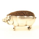 A large silver pin cushion in the form of a standing pig, Birmingham, by Sanders and Hollings, 8cm.