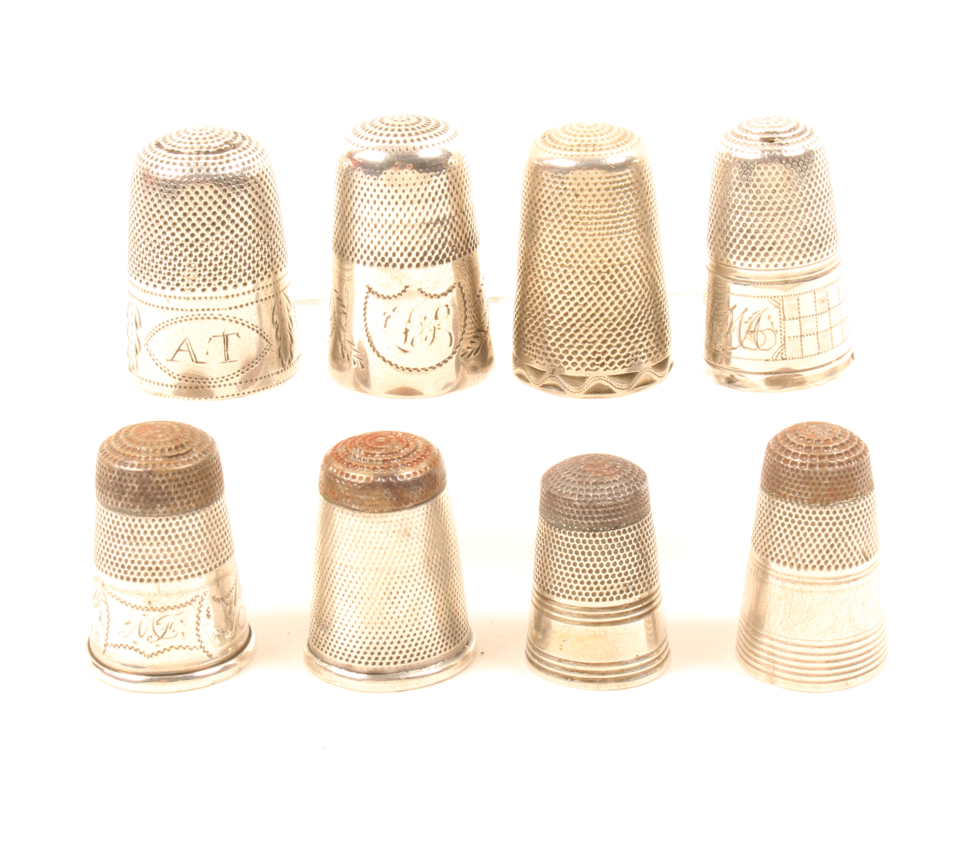 Eight early 19th Century English silver thimbles comprising four with steel tops and four tall