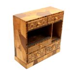 A Japanese geometric inlaid table cabinet fitted five drawers with two open compartments, formerly