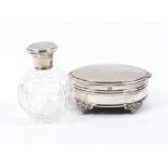 An oval silver dressing table box and a scent bottle the box with engine turned lid within a