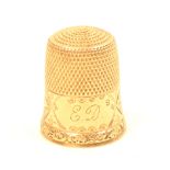 An American gold thimble, initialled ‘ED’ within an ivy and frosted frieze over a raised scroll