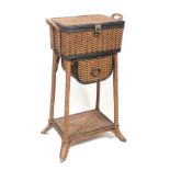 A late 19th Century basket weave sewing table, the hinged lid revealing a green silk interior over a