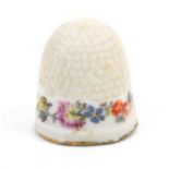 A Meissen porcelain thimble painted with a band of flowers and foliage over a gilt line, the upper
