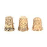 Three American gold thimbles comprising an example with decorated border and dated, 1873, another
