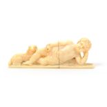 A fine early 19th Century French ivory needlecase, carved as a reclining cupid, one hand