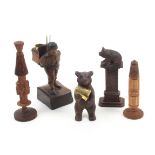 Five carved continental wooden needlecases and thimble stands comprising a male standing example