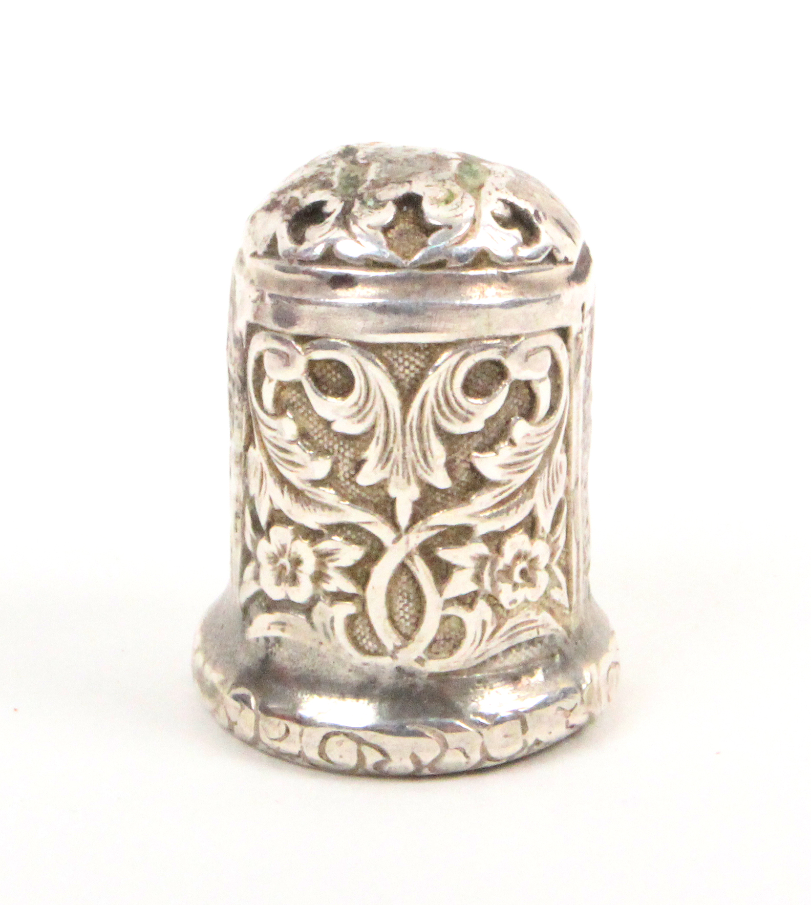 A 17th/18th Century silver thimble the body chased with leaf scrolls and flowers over an engraved