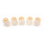 A set of five mother of pearl top reel holders, floral tops, brass stems on bone bases, 2.6cm dia (