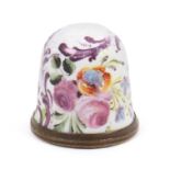 An 18th Century South Staffordshire enamel thimble brightly decorated all over with flowers and