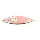 A pretty American enamel decorated tatting shuttle, one face enamelled with flowers on a pink