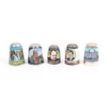 A silver thimble enamelled by Peter Swingler and four enamel thimbles by James Swann and Son,