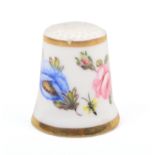 A 19th Century Derby porcelain thimble painted with colourful groups of flowers between gilt