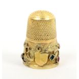 A 19th Century gold thimble the frosted ground frieze with a vacant cartouche with a band of