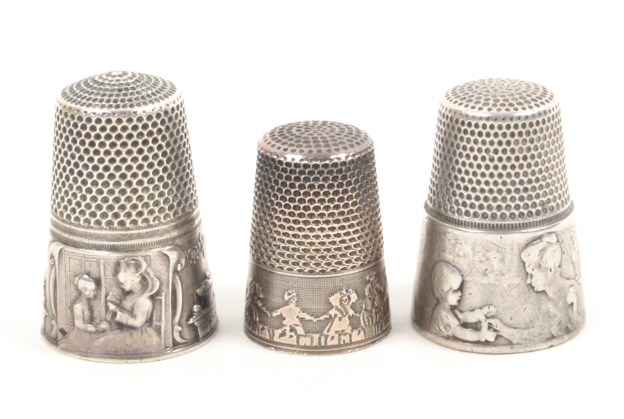 Three continental silver thimbles comprising two French examples designed by Vernon each depicting a