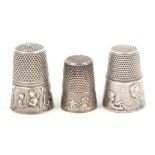 Three continental silver thimbles comprising two French examples designed by Vernon each depicting a