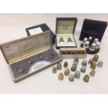A collection of thimbles comprising a cased pair of silver thimbles issued by The Royal Mint for the