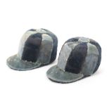 A pair of jockey cap pin cushions in alternate panels of blue cloth, with pin stuck decoration,