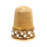A 19th Century gold thimble with a border of pearls set in pairs in leaf form mounts between rope