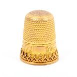 A gold thimble with a vacant rectangular cartouche within an engraved frieze over a raised border