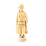 An early 19th Century carved ivory Dieppe fisherman needlecase, of standing form in traditional
