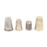 Four English thimbles comprising an 18th Century childÍs silver filigree example, another with