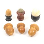 Six thimble cases comprising three vegetable ivory acorns, an egg cup and egg, a turned yew wood