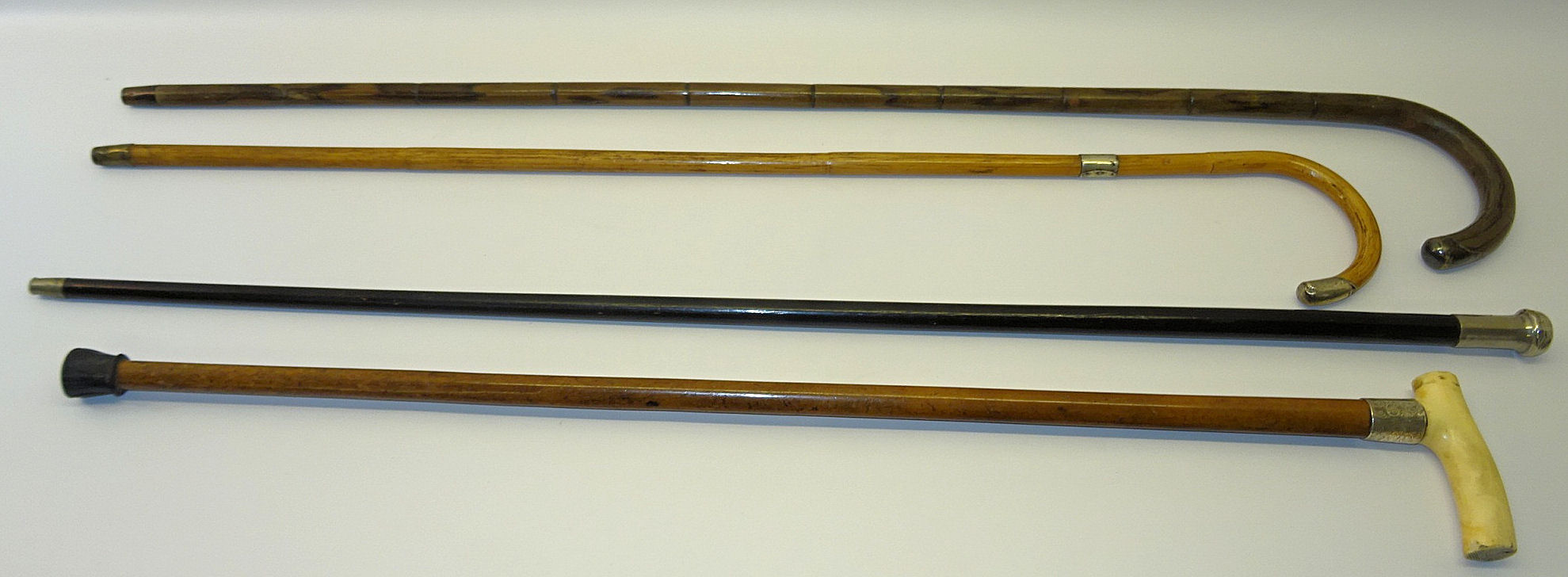 A partridge wood Walking Stick, an ebonised evening cane and two other sticks.