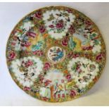 A Cantonese Plate decorated with panels of birds, figures etc. in famille rose and other coloured