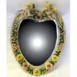 A Berlin heart shape wall Mirror, the frame applied with two cherubs holding a garland of flowers