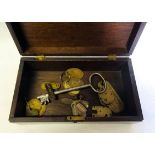 A 19th Century mahogany Box containing a number of old brass key fobs, variously inscribed etc.