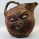 A Martin Bros stoneware double sided face Jug, both sides with a leering design and with loop