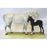 A Beswick model of a grey Mare and a black Foal on an oblong plinth, no. 1811.