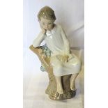 A Lladro Figure of a seated child. 8" (20cms) high.